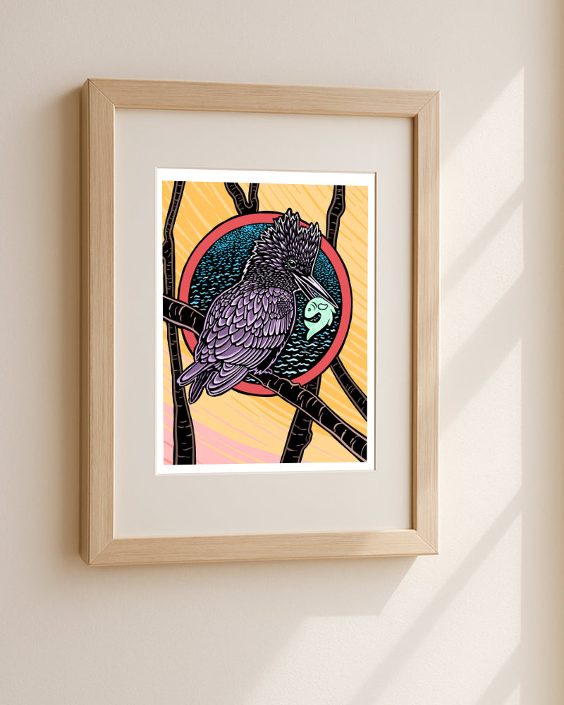 Framed artwork of a kingfisher with a fish in its mouth two birds flying against a colorful background hanging on a white wall.