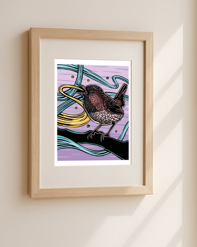 Framed artwork of a wren with a purple background hanging on a light beige wall.