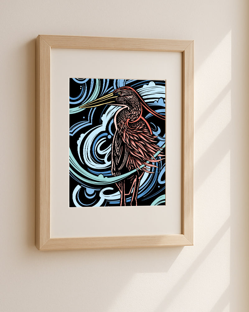 Framed artwork of a heron with a swirling blue background on a white wall.