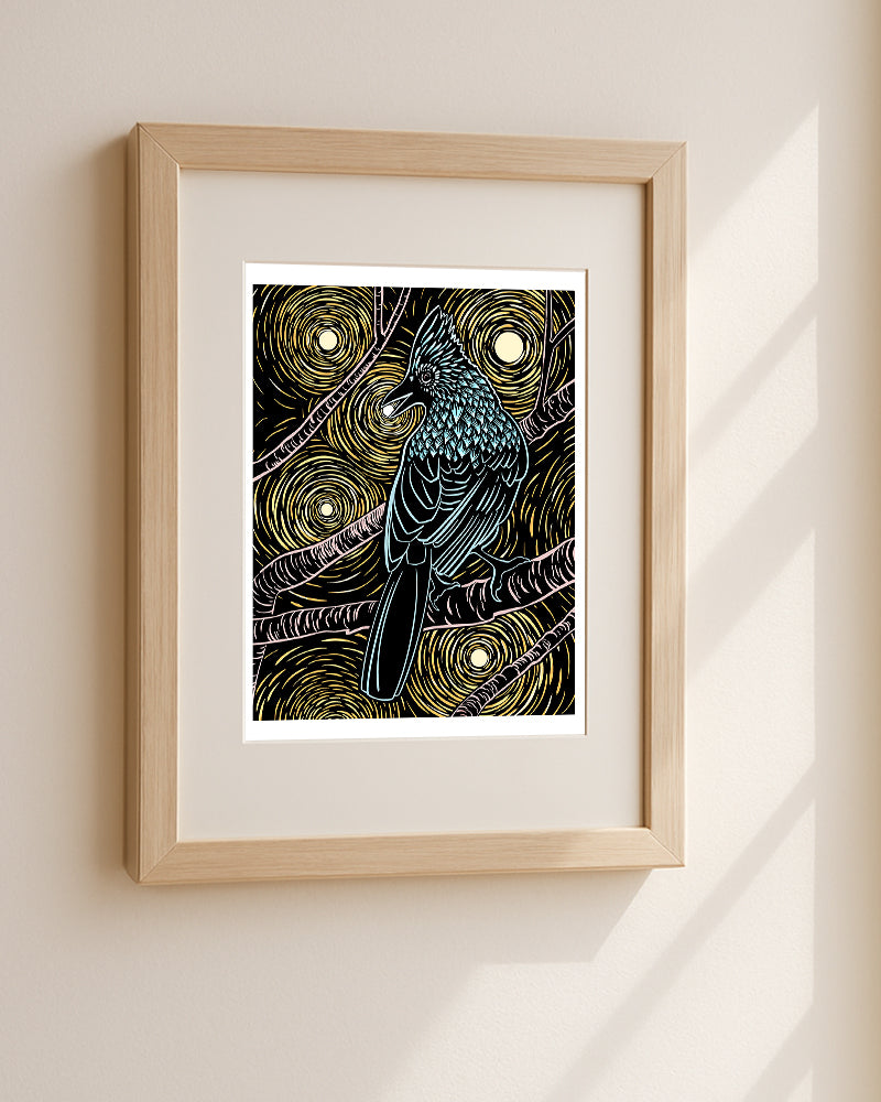 Framed artwork of a steller’s jay with a starry night background on a beige wall.