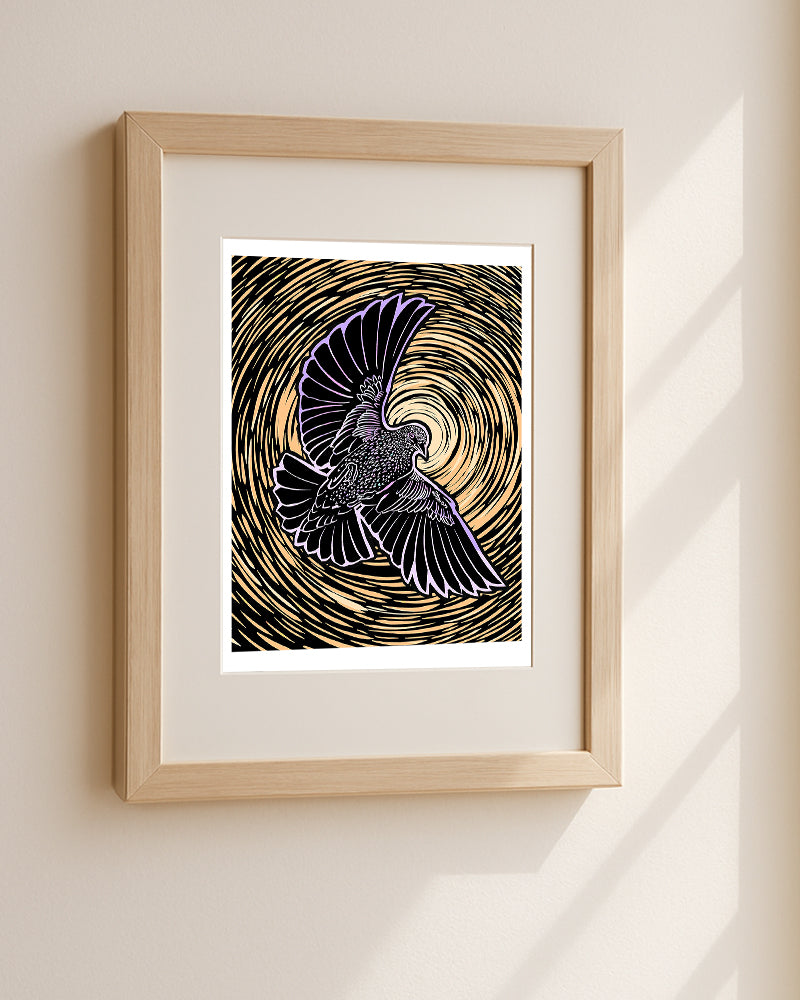 Framed artwork of a starling in flight hanging on a beige wall.