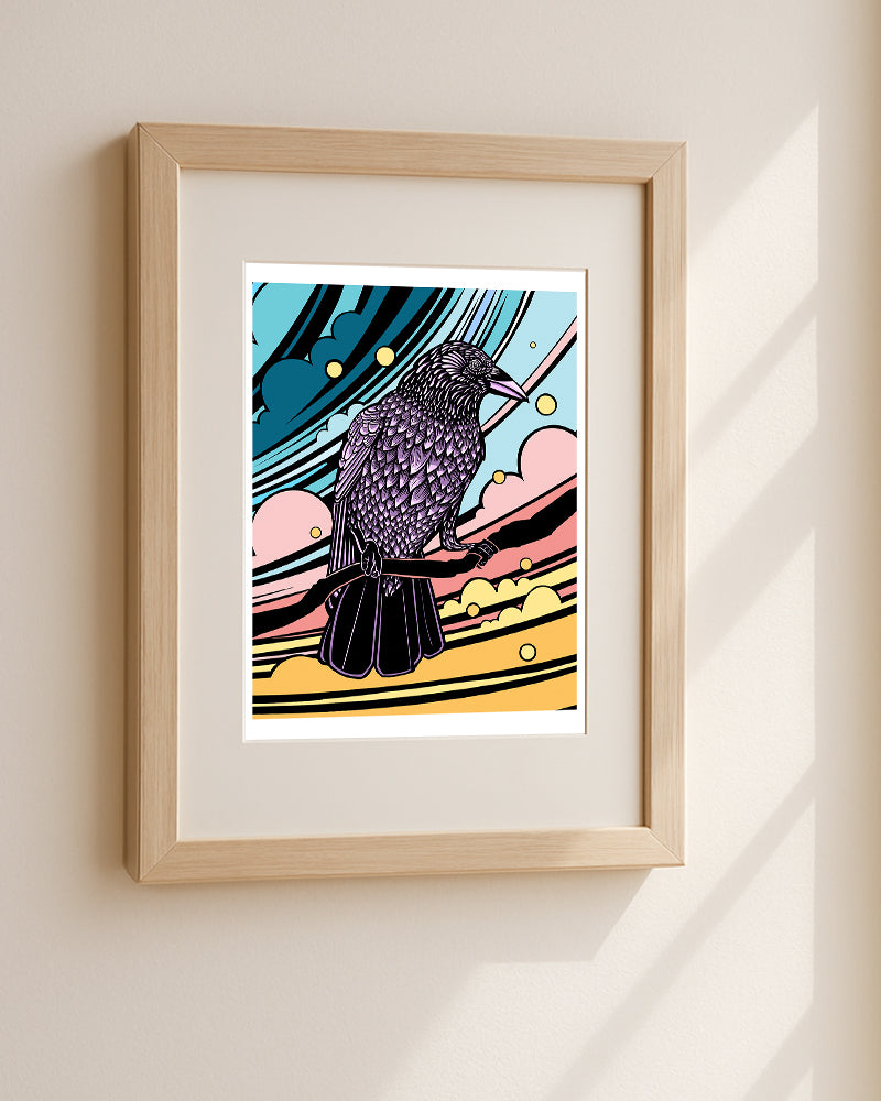 Framed artwork of a stylized crow with colorful abstract background hanging on a beige wall.